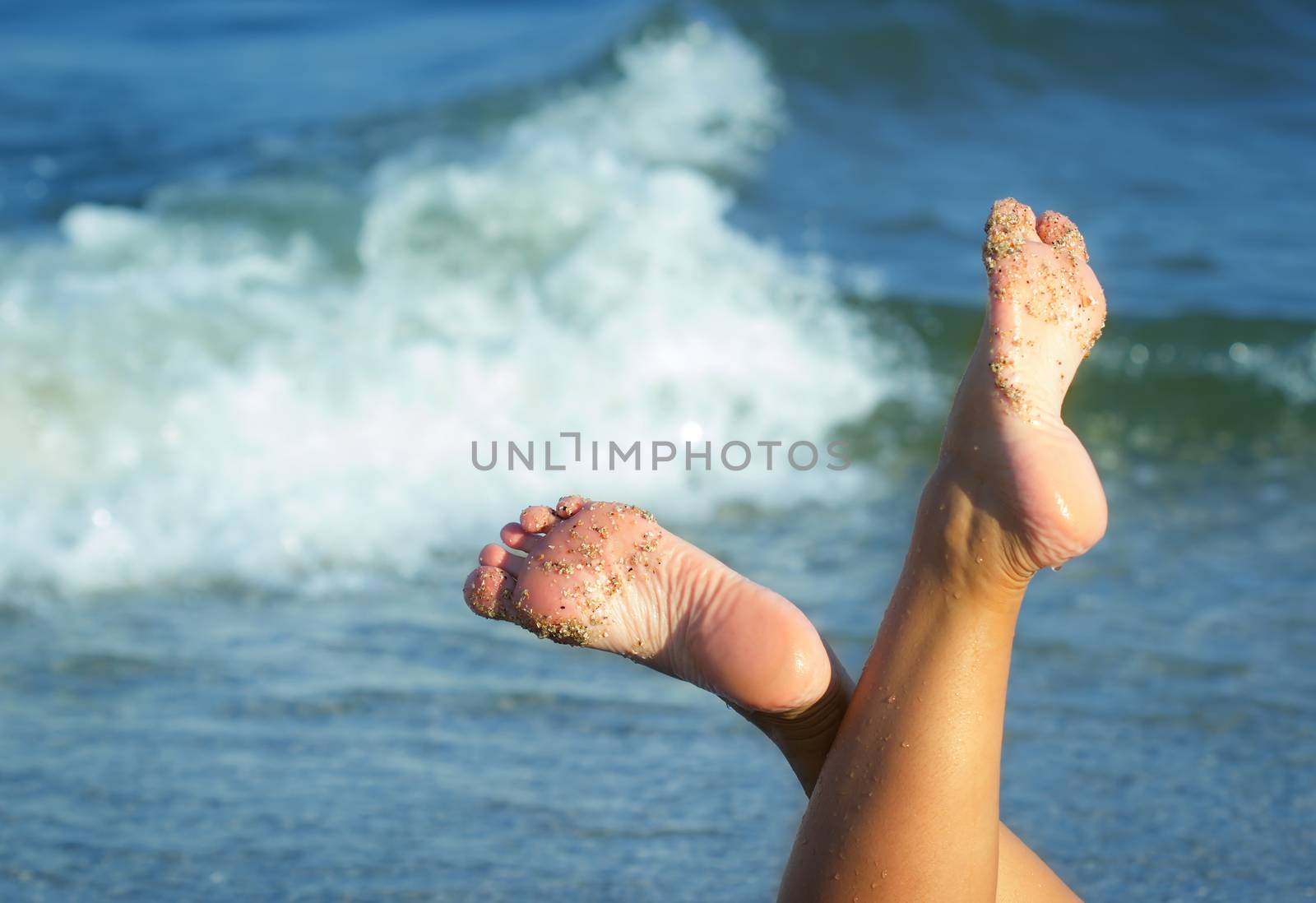 Close up of female feet on sandy beach