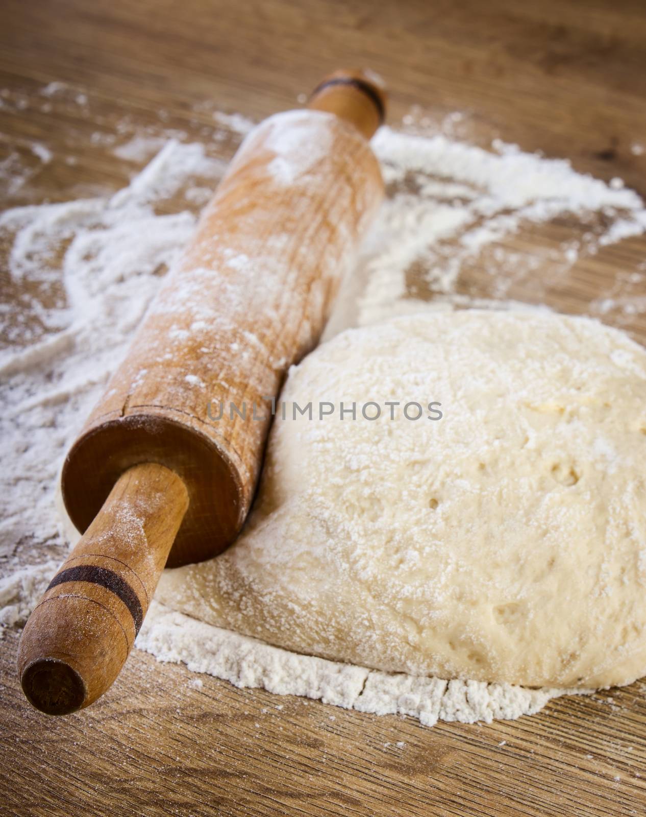 Dough with rolling pin on wooden table