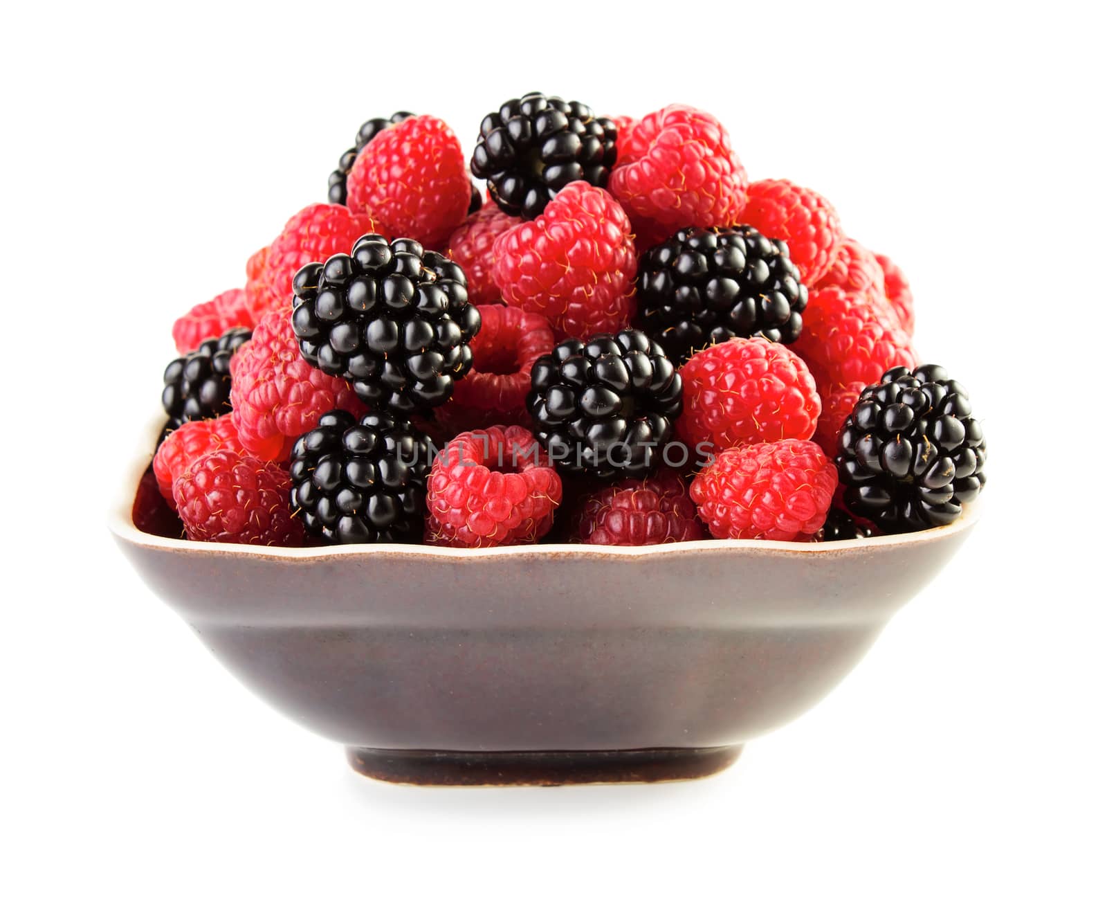 Saspberries and blackberries in plate isolated on white background