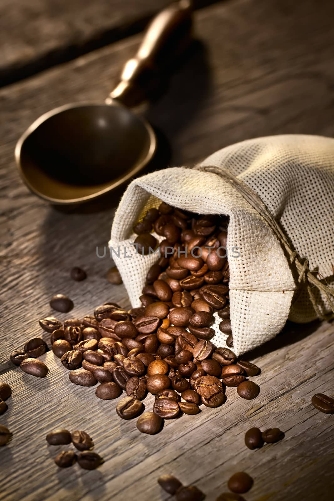 Coffee beans in the burlap sack on wooden table