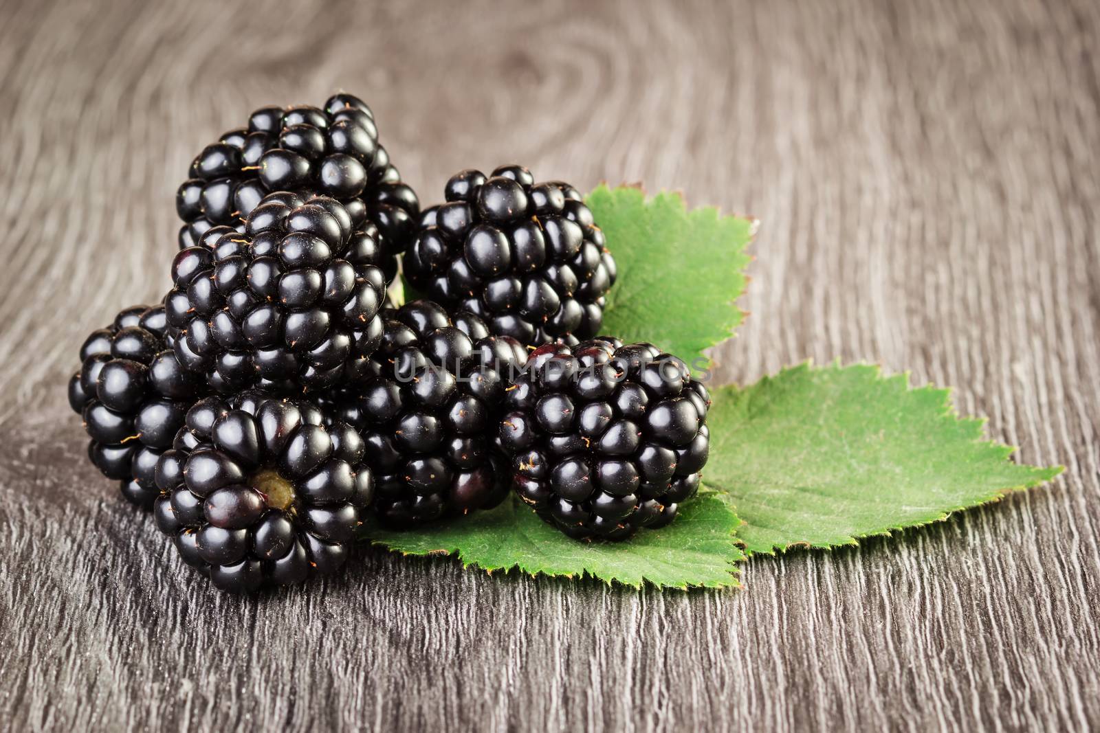 Blackberries with leaf on wooden background