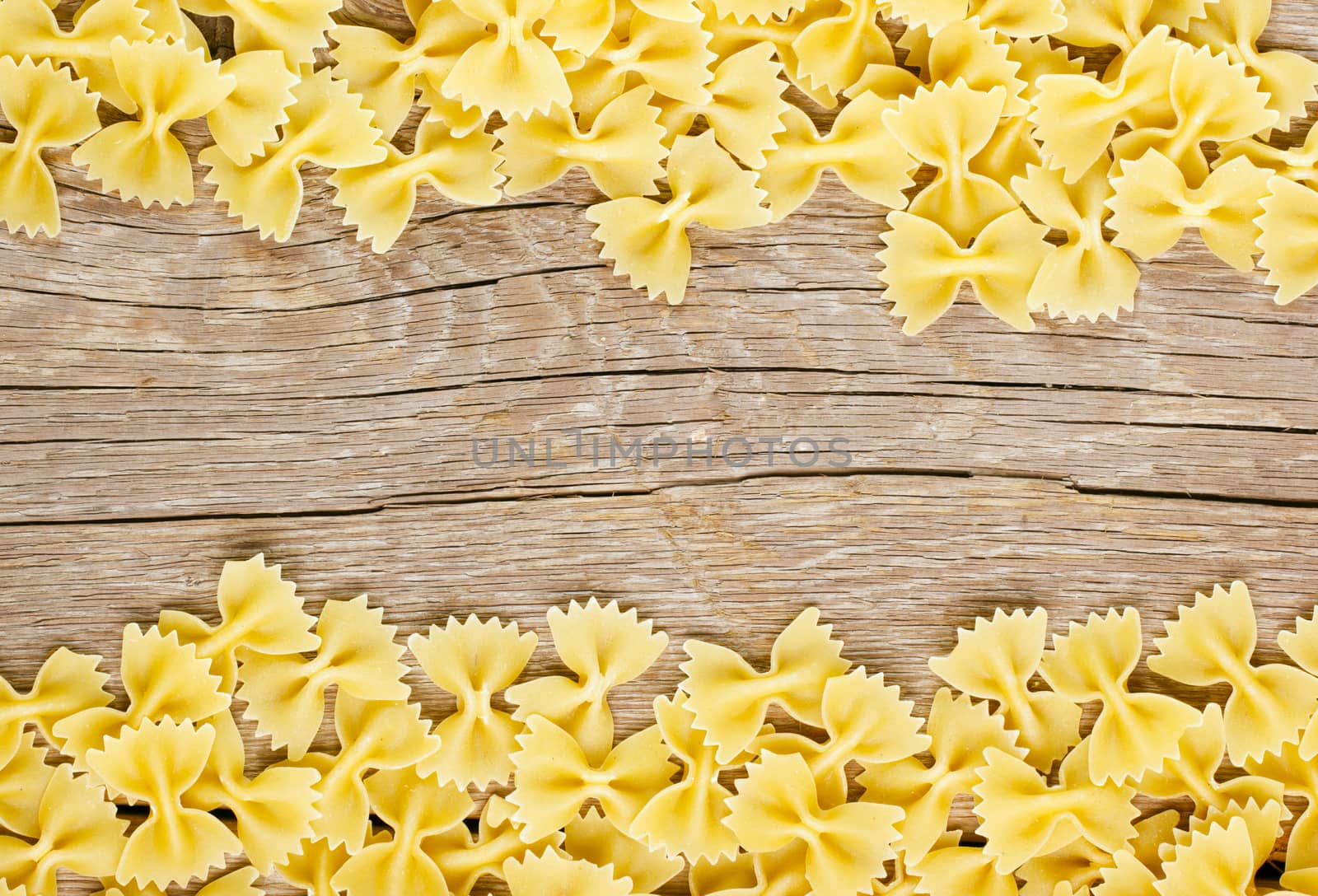 Raw farfalle pasta on wooden background