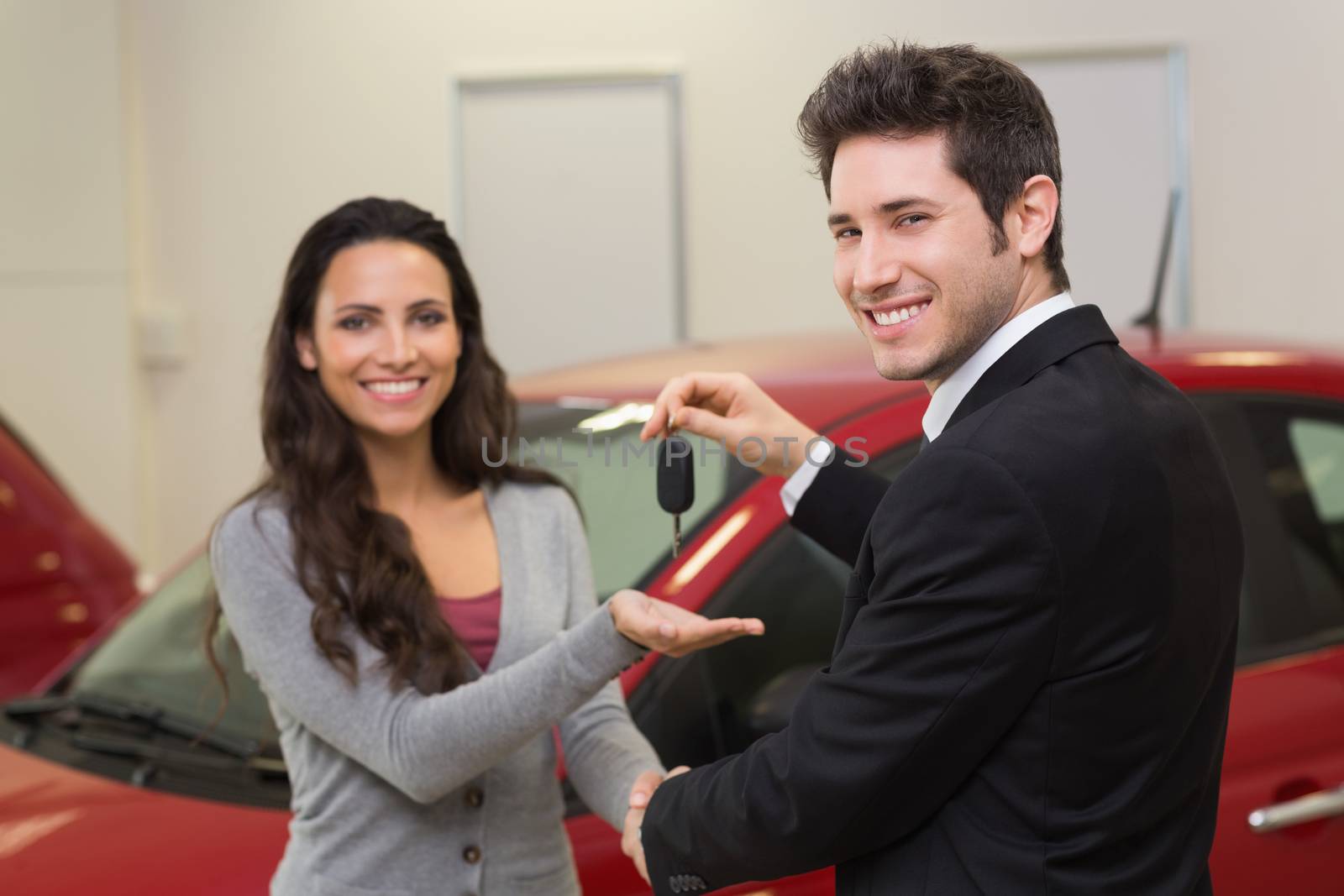 Businessman giving car key while shaking a customer hand by Wavebreakmedia