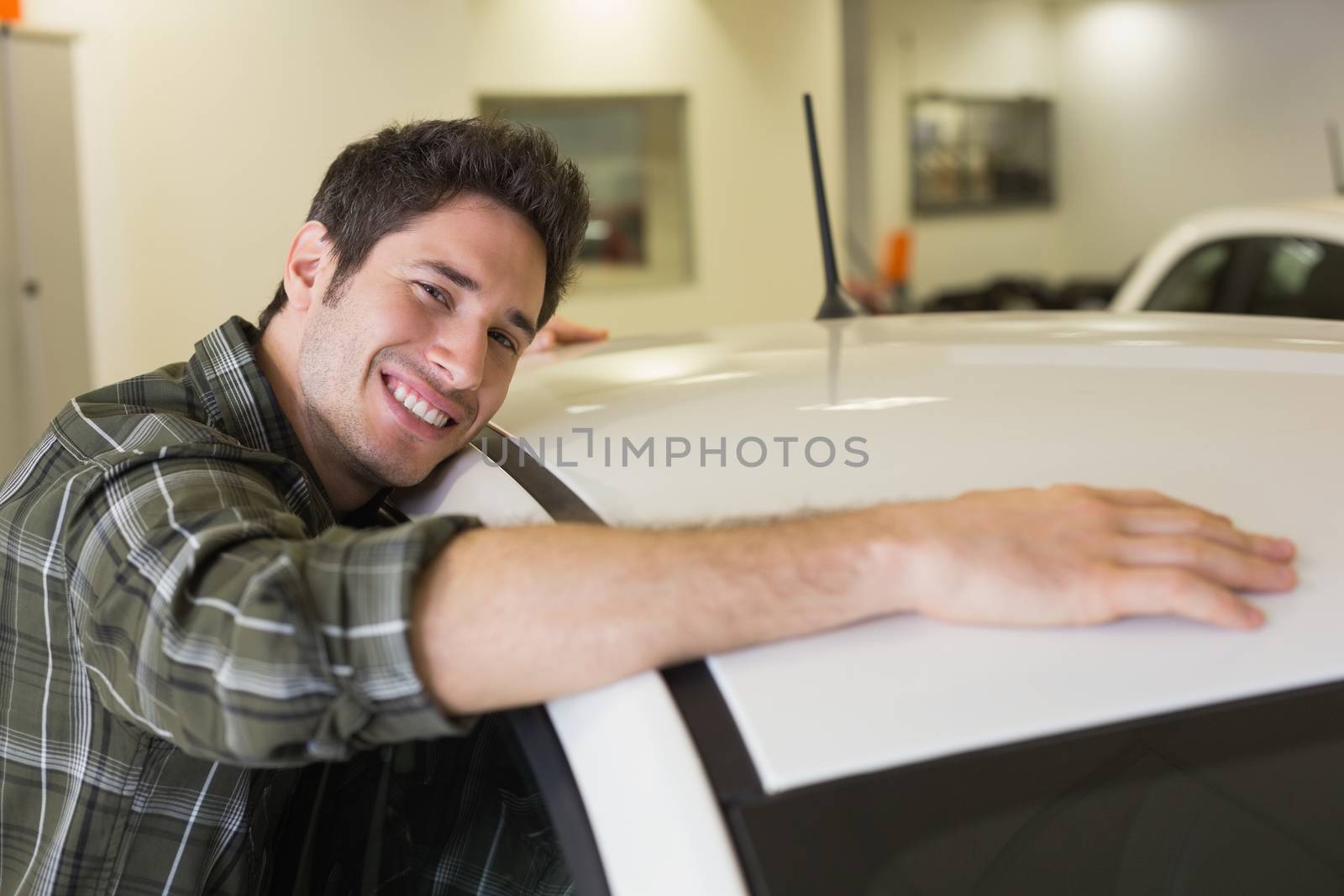 Man hugging on a car at new car showroom