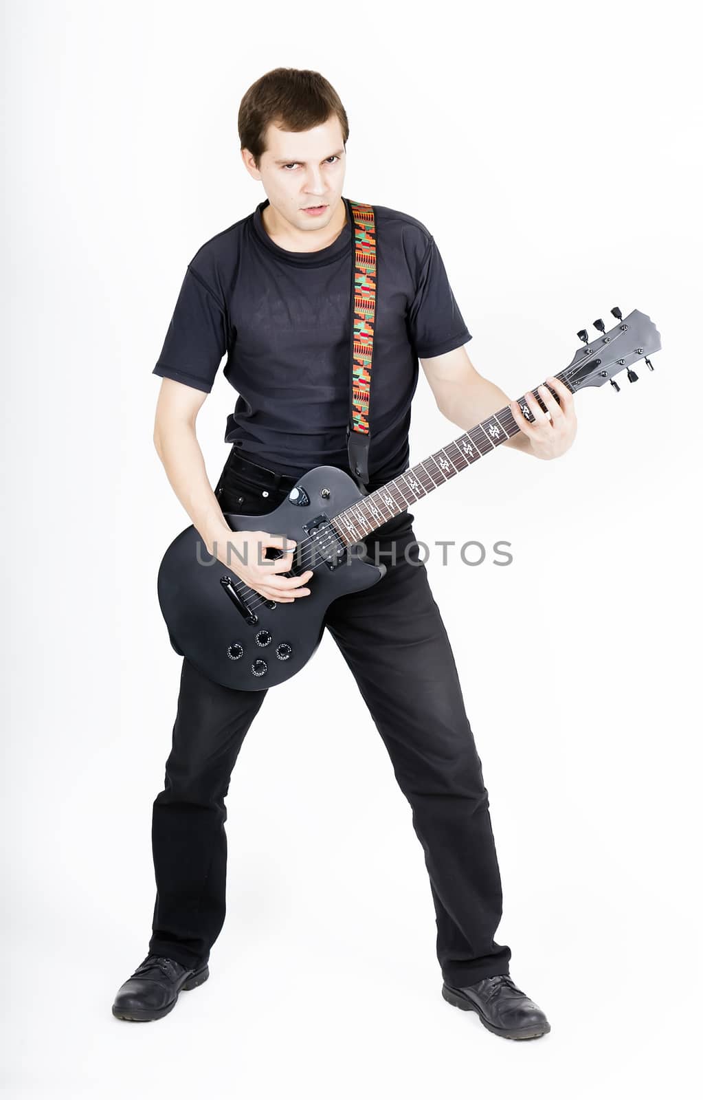 Young man with a black electric guitar