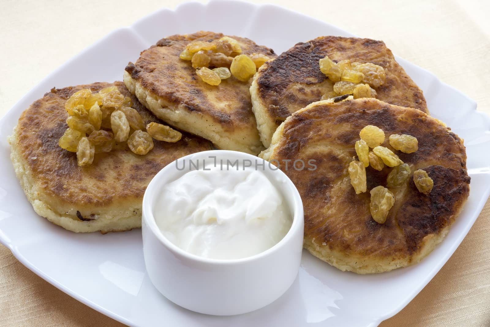 Cottage cheese pancakes ,raisins and sour cream.
