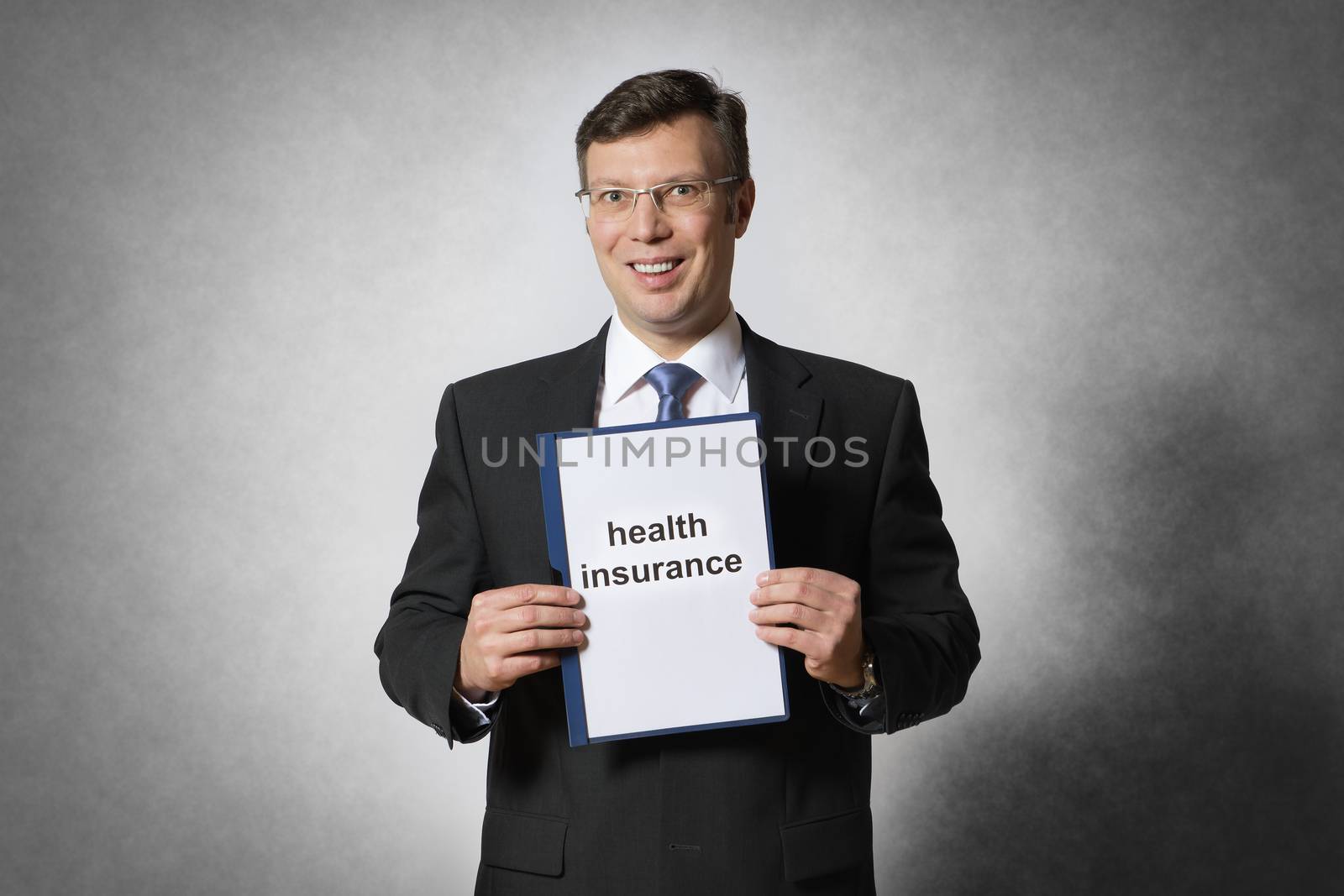 Happy businessman is holding a health insurance contract