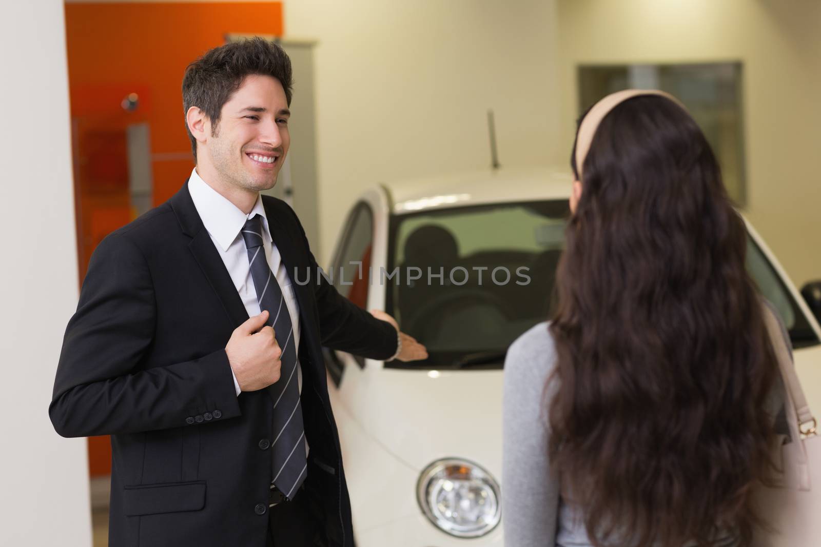Businessman showing a car to a woman by Wavebreakmedia