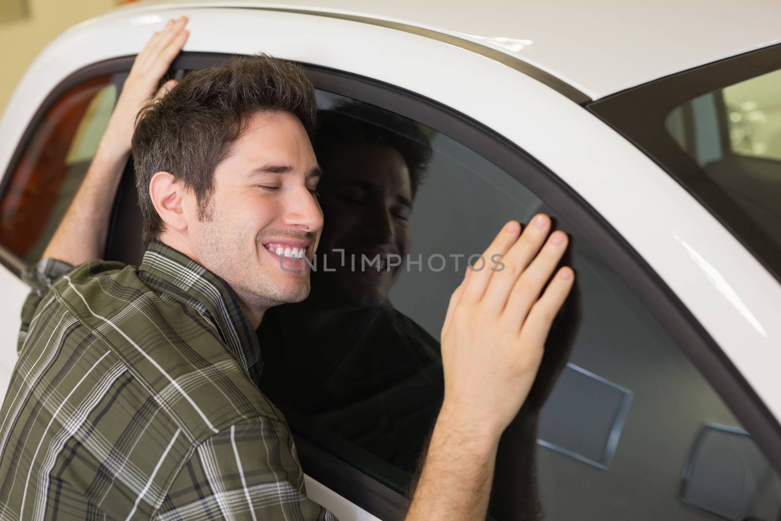 Man hugging on a car at new car showroom