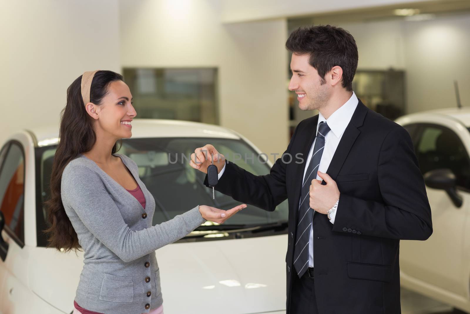 Smiling businessman giving car key to happy customer by Wavebreakmedia