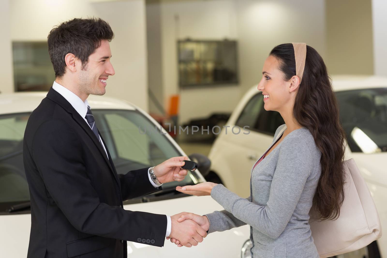 Businessman giving car key while shaking a customer hand by Wavebreakmedia