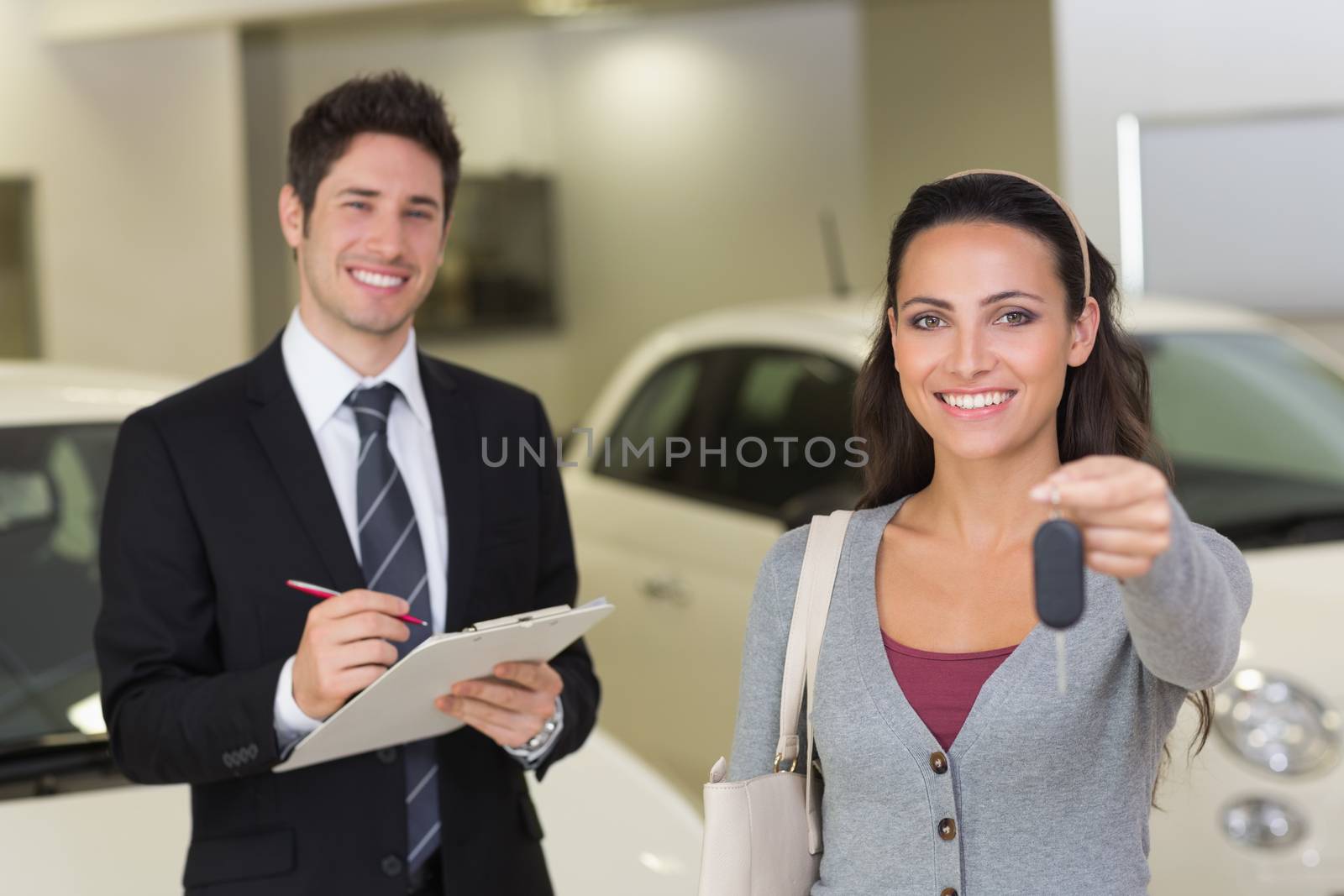 Female driver showing a key after bying a new car by Wavebreakmedia
