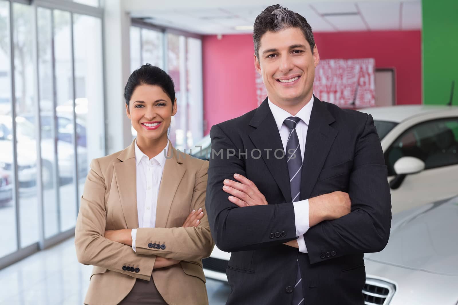 Smiling colleagues standing with arms crossed by Wavebreakmedia