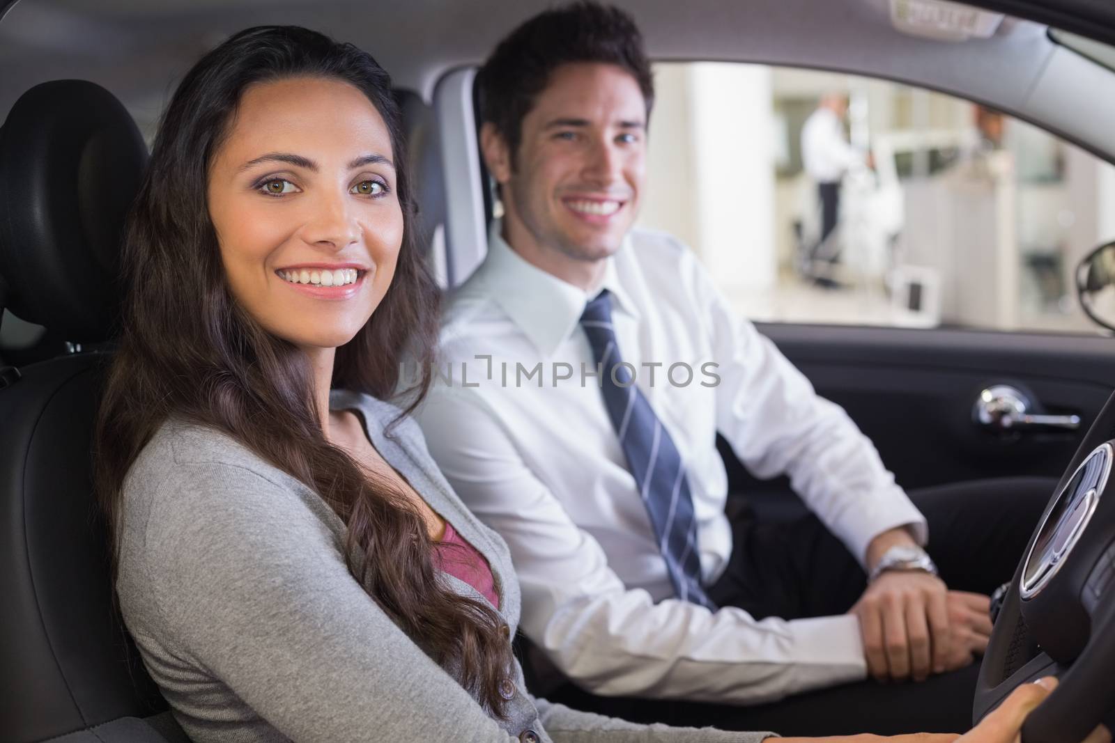 Female driver at the wheel sitting in her car with salesperson by Wavebreakmedia