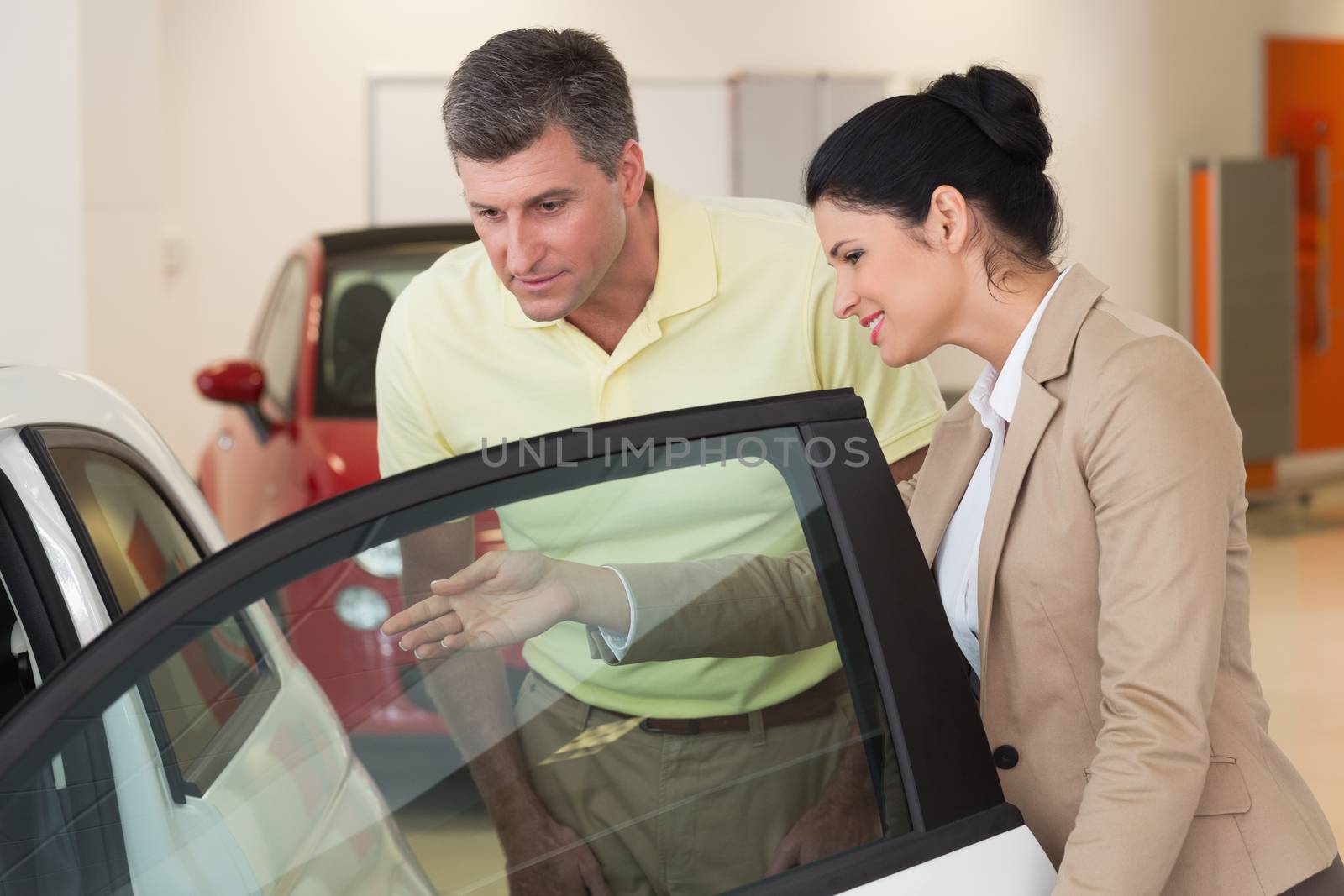 Businesswoman showing a car interior to her customers by Wavebreakmedia