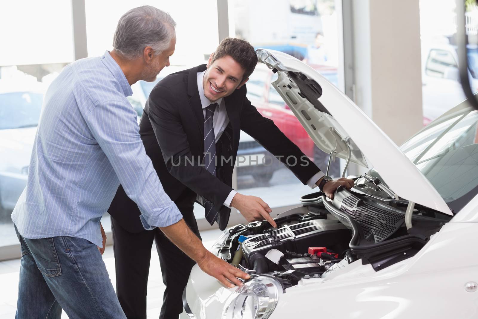 Two men looking at a car engine by Wavebreakmedia