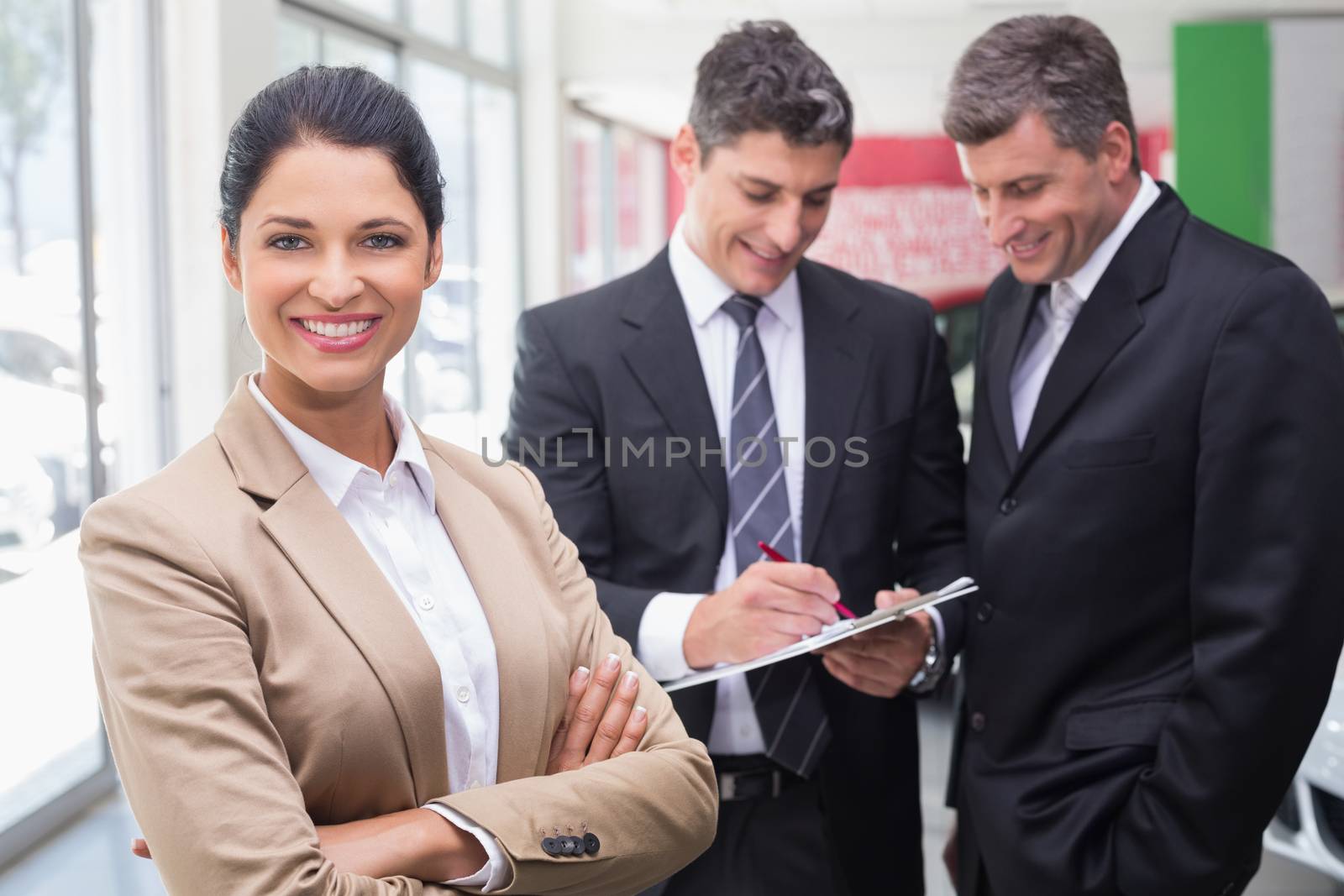 Businessman writing on clipboard talking to colleague by Wavebreakmedia