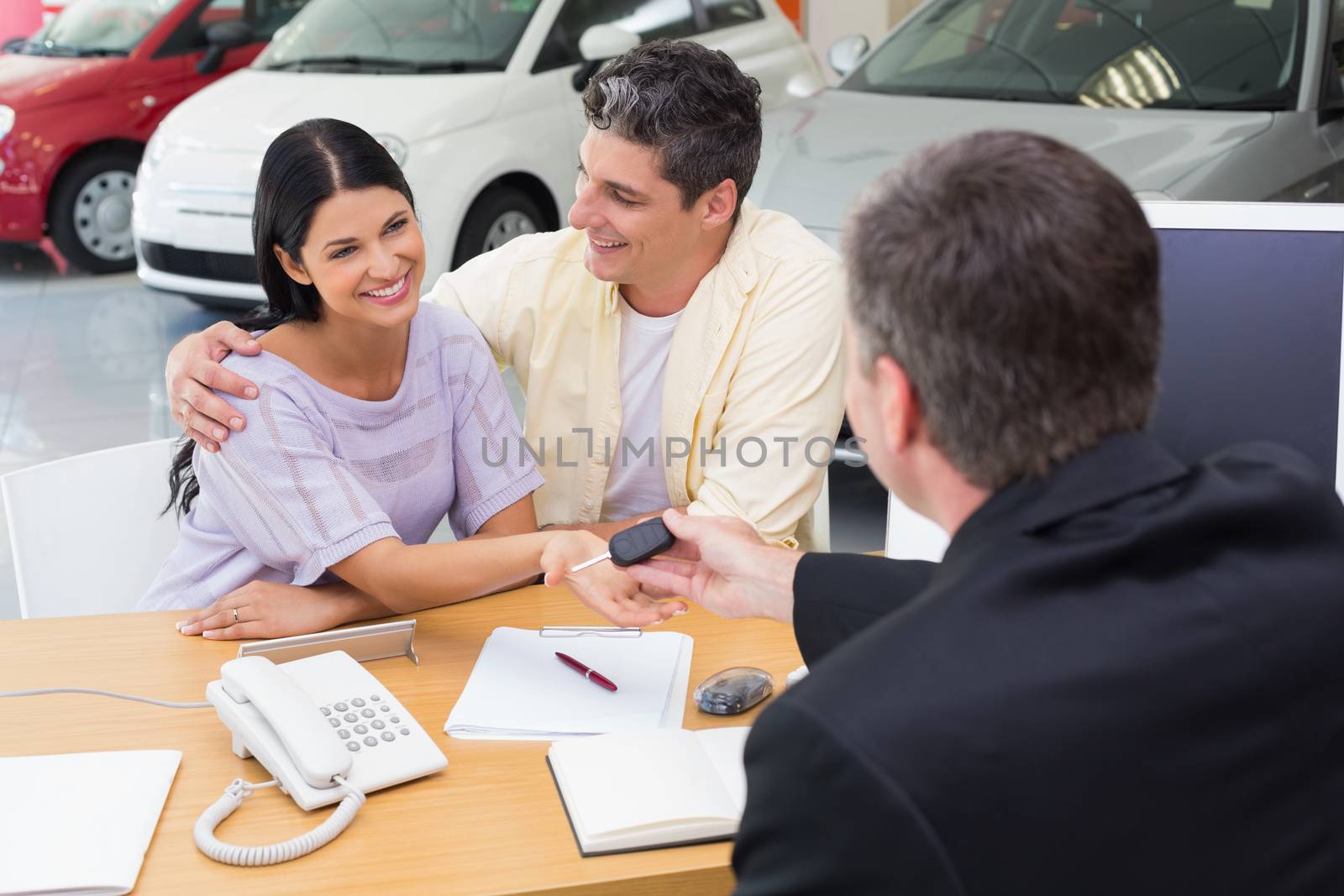 Salesman giving key to a smiling couple by Wavebreakmedia