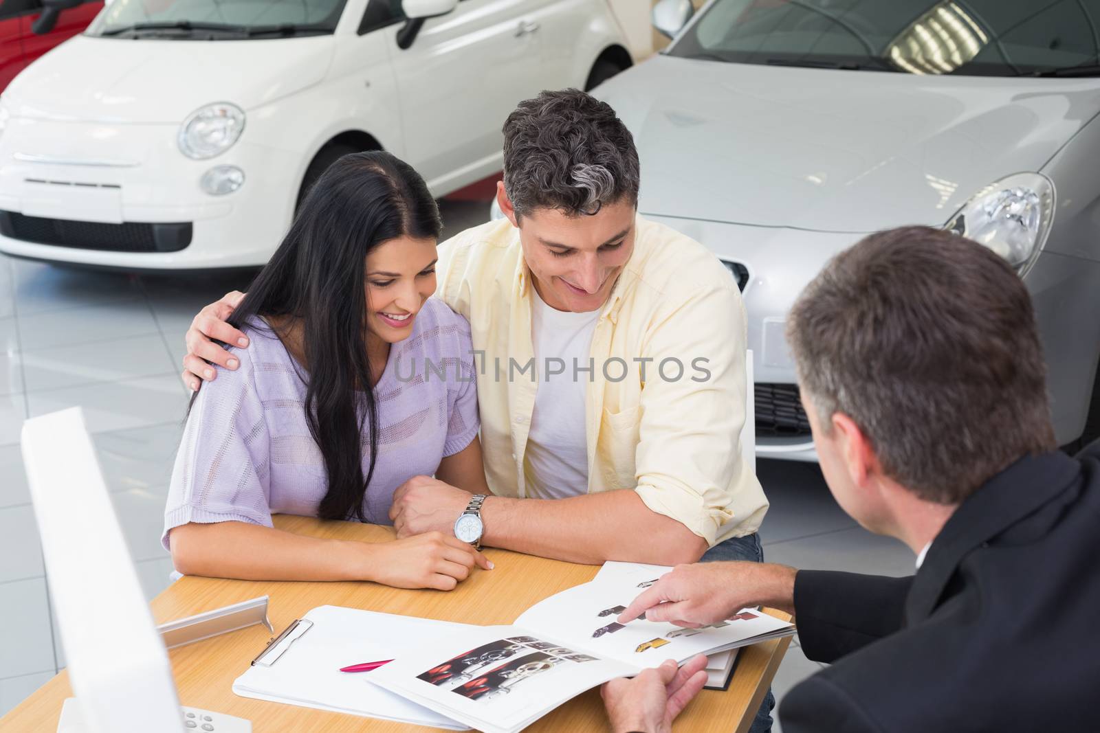 Salesperson pointing something on booklet by Wavebreakmedia