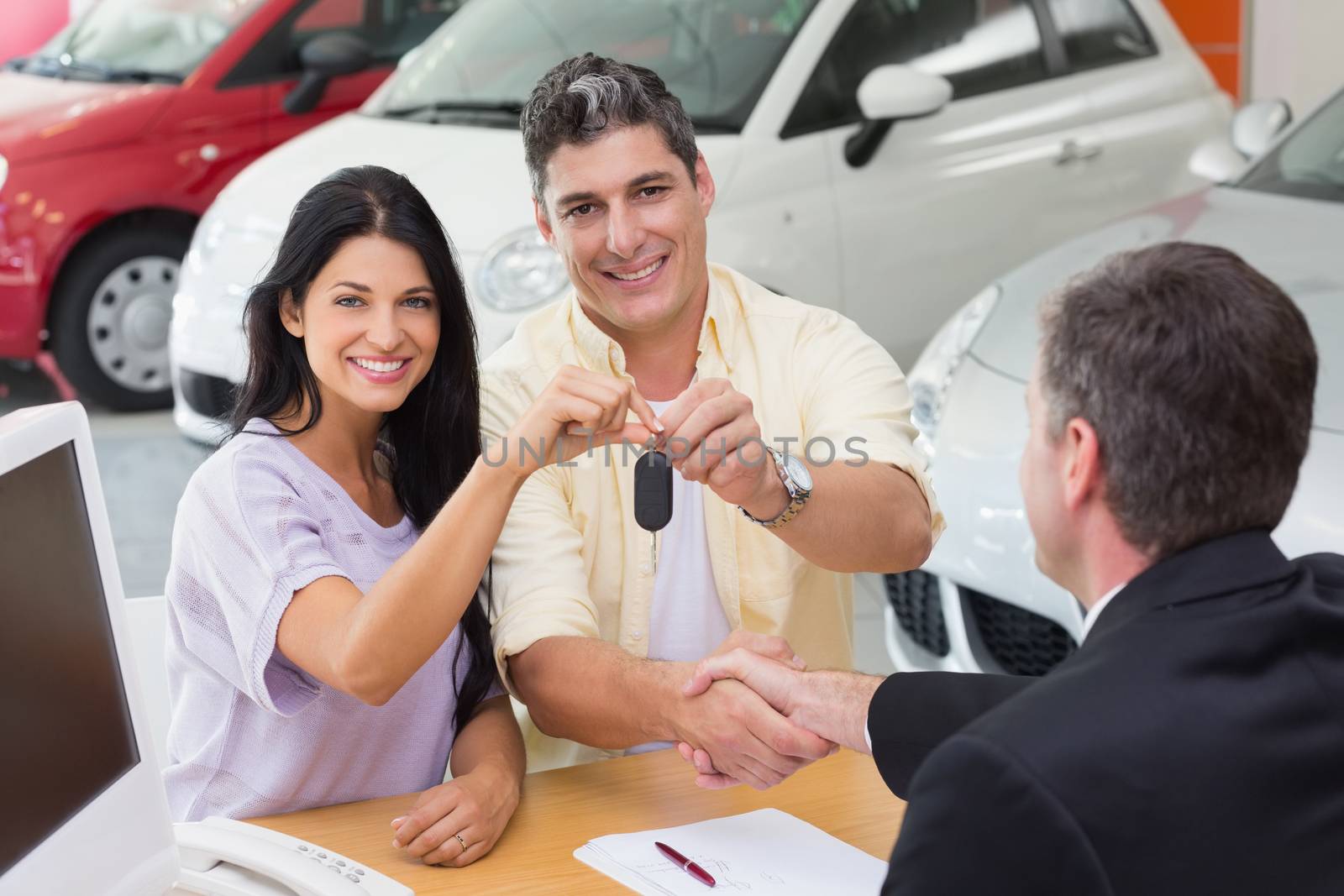 Smiling couple holding their new car key by Wavebreakmedia