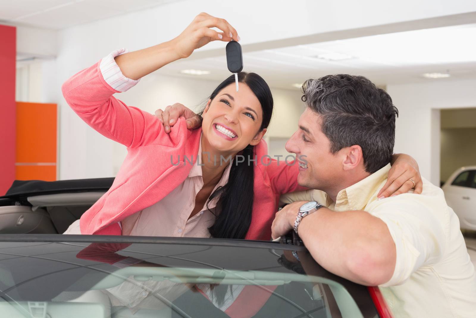 Smiling couple buying a new car by Wavebreakmedia