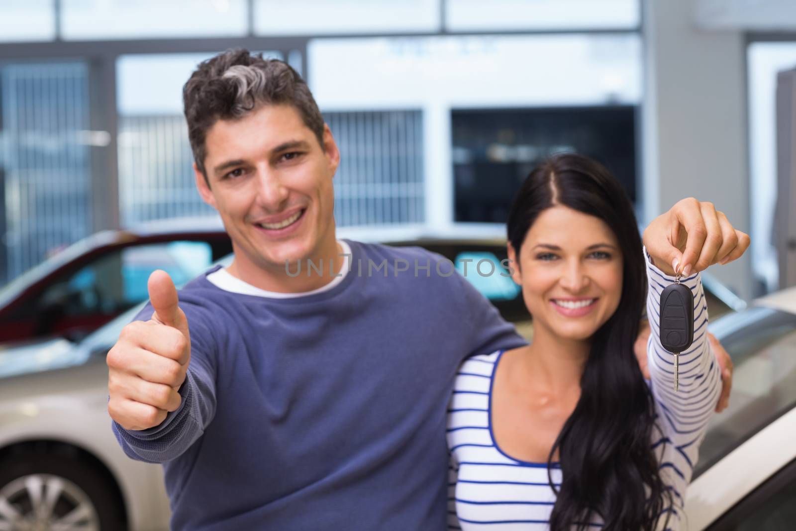 Smiling couple holding their new car key by Wavebreakmedia