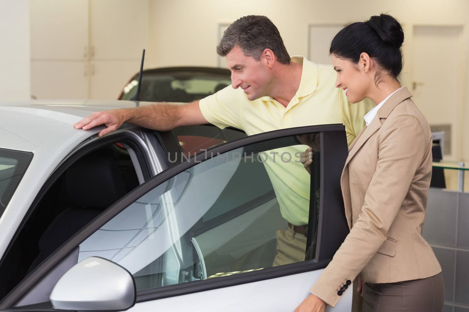 Businesswoman showing a car interior to her customers by Wavebreakmedia