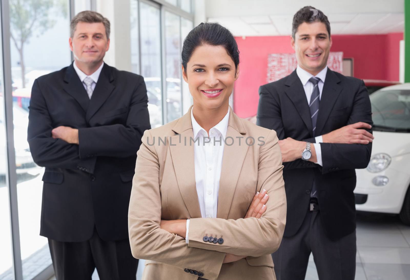 Smiling business team standing with arms crossed by Wavebreakmedia