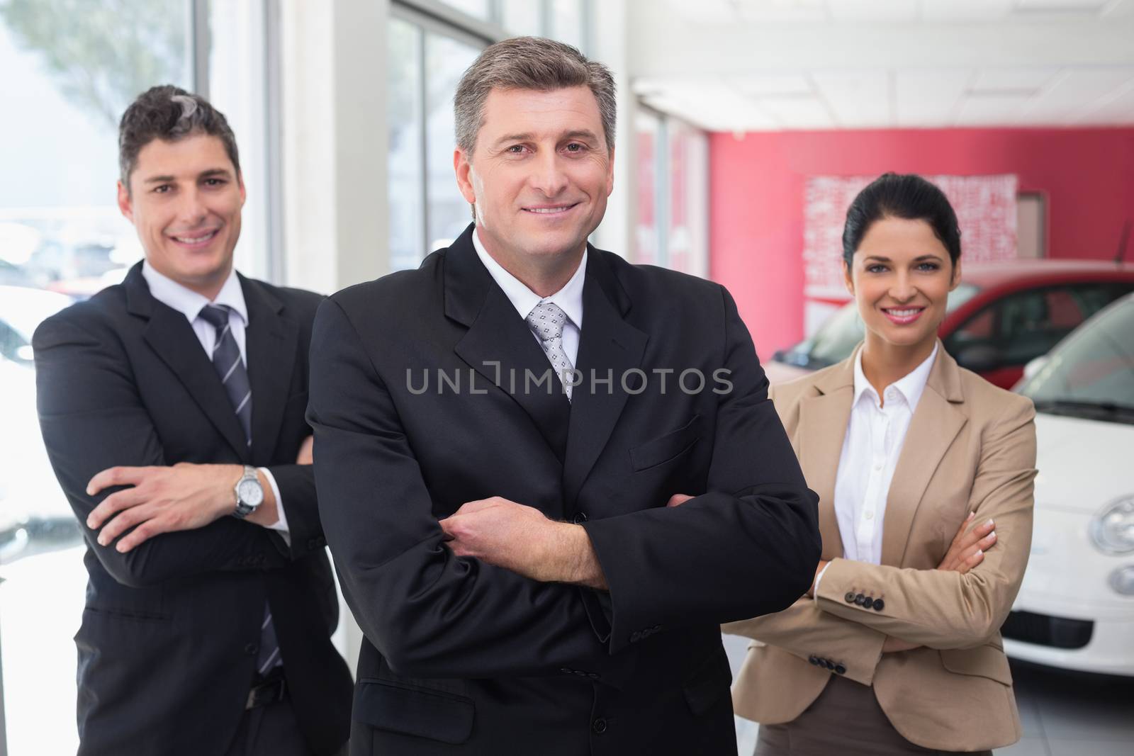 Smiling business team standing with arms crossed by Wavebreakmedia