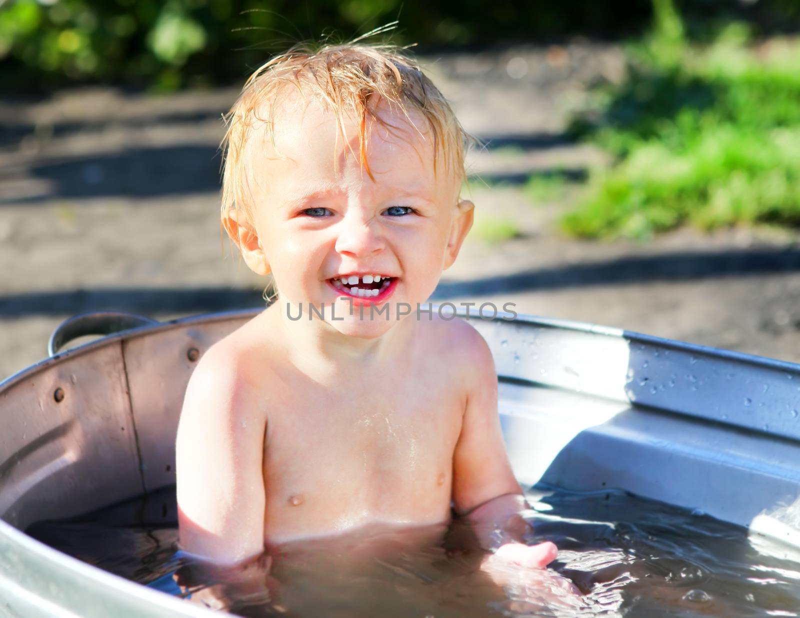 Happy Little Child bathing in Washbowl outdoor