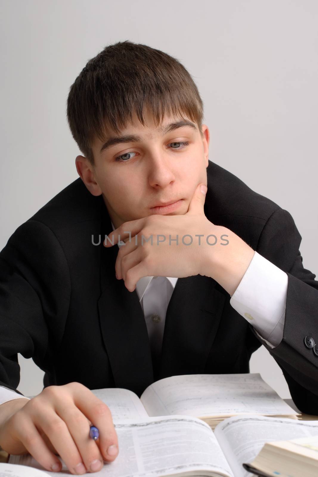 Student think at the School Desk on the Grey Background