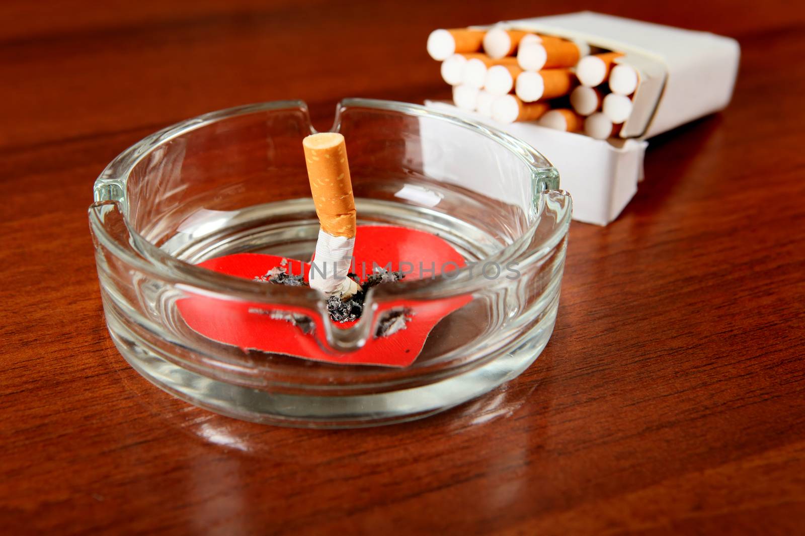 Cigarette in Ashtray with Heart Shape on the Table