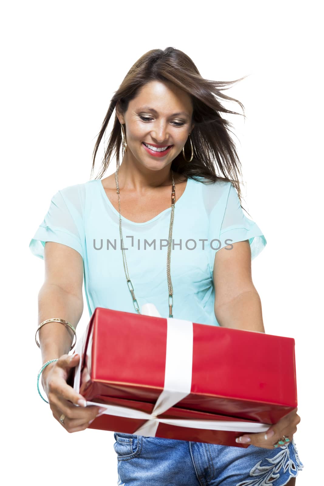 Close up Portrait of Happy Young Woman in Casual Clothing Holding a Red Big Gift Box with White Ribbon While Looking at the Camera. Isolated on White Background.