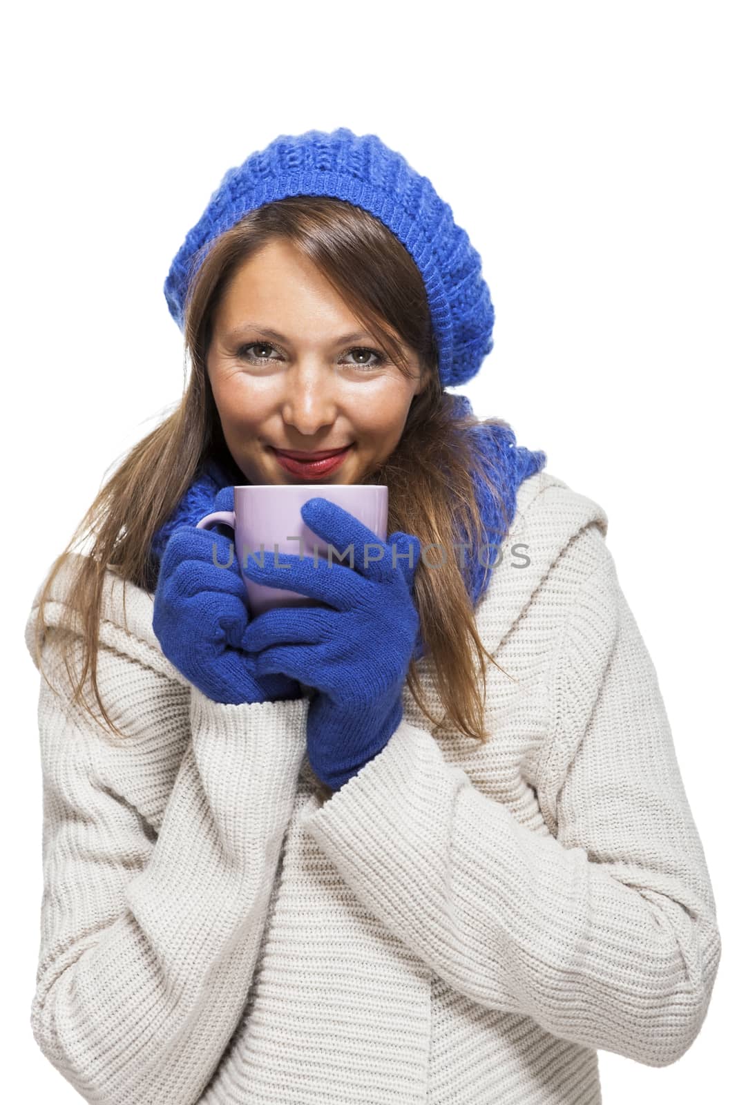 Close up Pretty Smiling Young Woman Wearing Winter Knit Outfit with Blue Bonnet, Scarf and Gloves. Captured in Studio with White Background While Looking at the Camera.