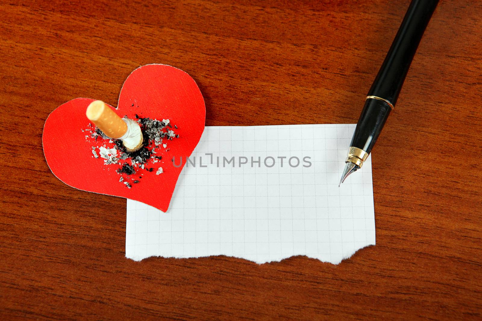 Cigarette in Heart Shape and Empty Paper on the Table