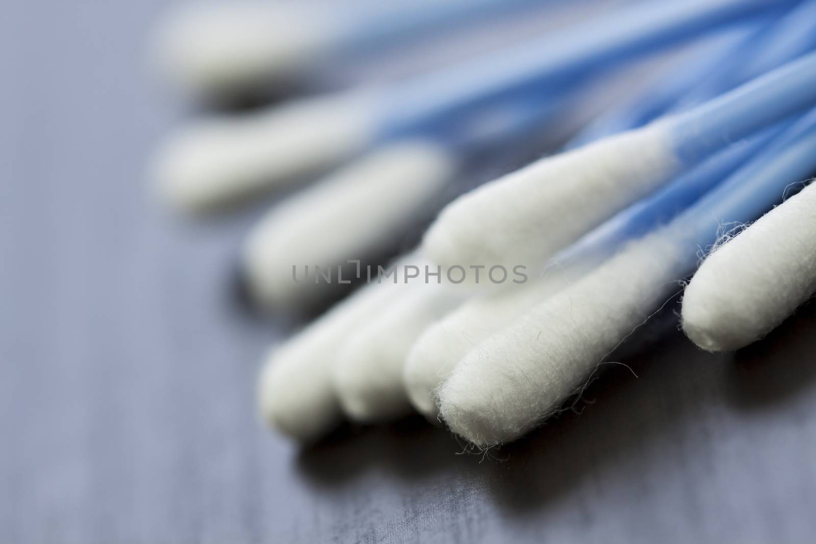 Random pile of blue plastic cotton ear buds for cleaning wax out of the ear in a health and hygiene concept