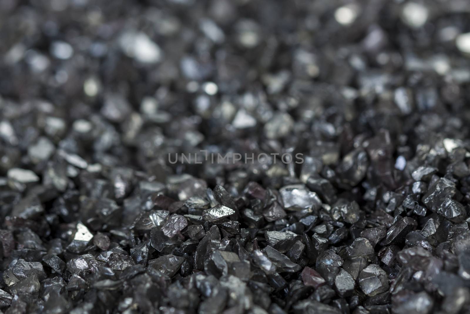 Background texture of an asphalt or tarmac road surface showing the tiny stones in the gravel with shallow dof