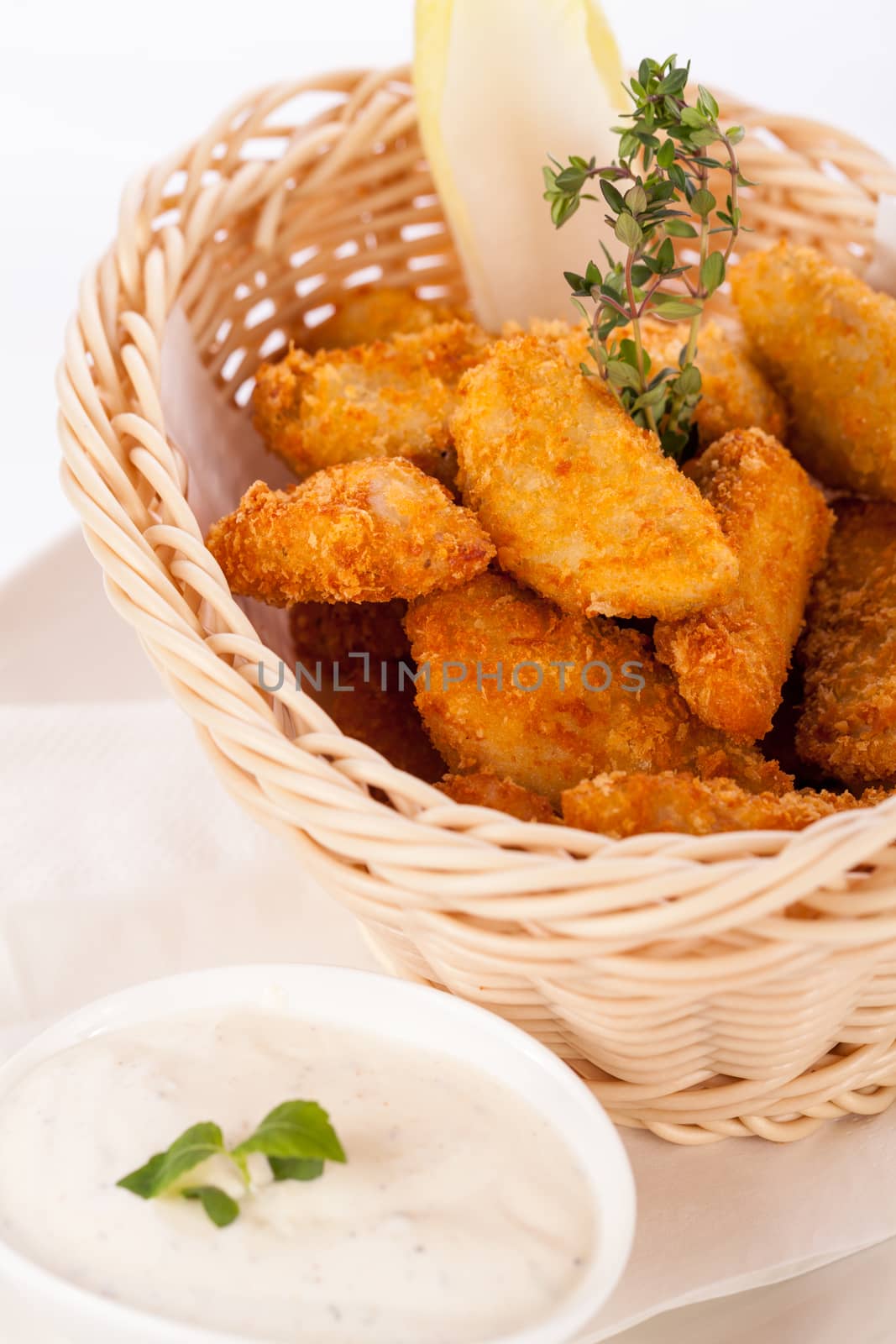 Crumbed chicken nuggets in a basket by juniart