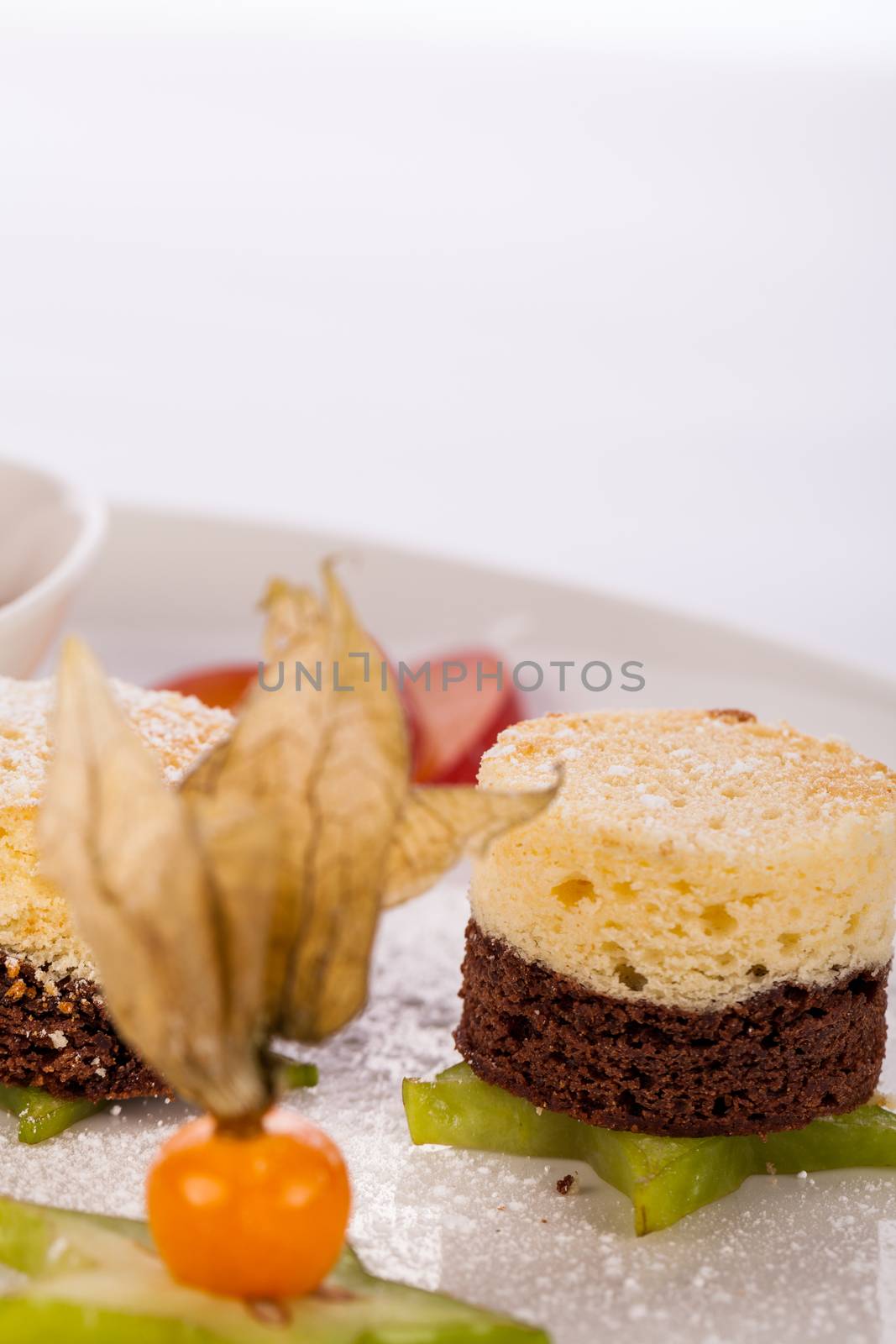 Gourmet coffee and chocolate blanc mange with a colourful ripe Cape gooseberry and sliced carambola or star fruit served on a plain white plate