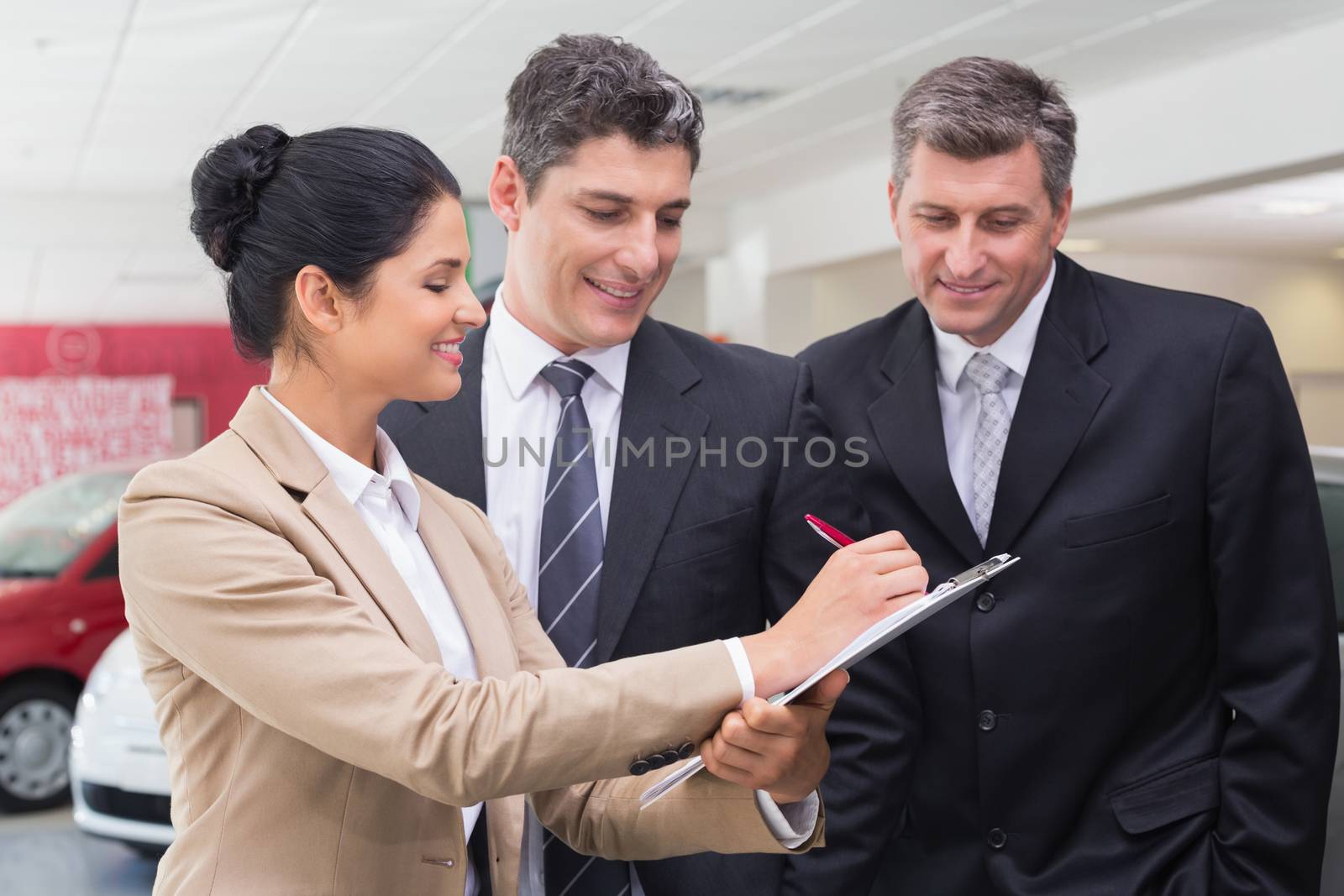 Smiling business team working together on clipboard by Wavebreakmedia