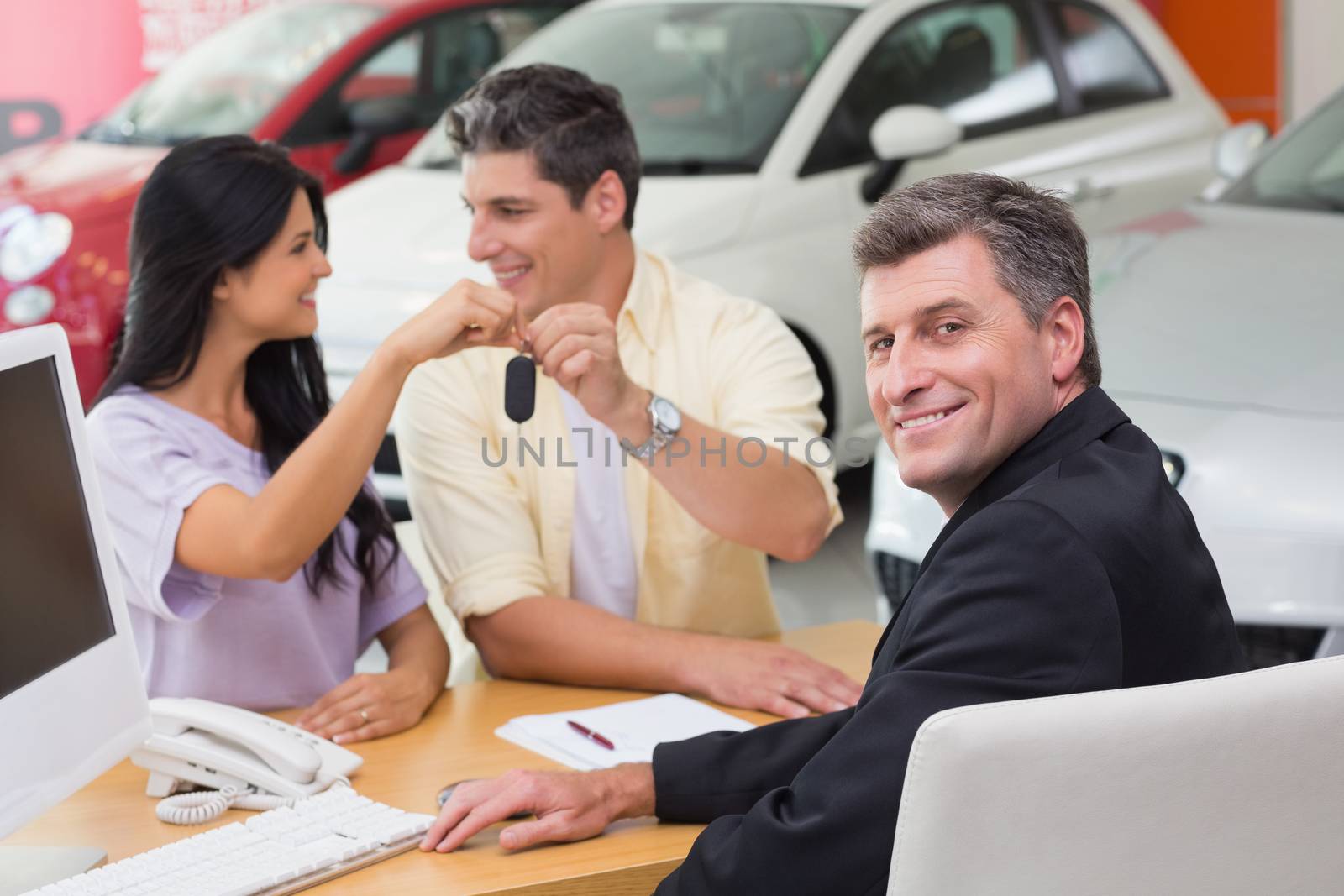 Smiling couple holding their new car key by Wavebreakmedia