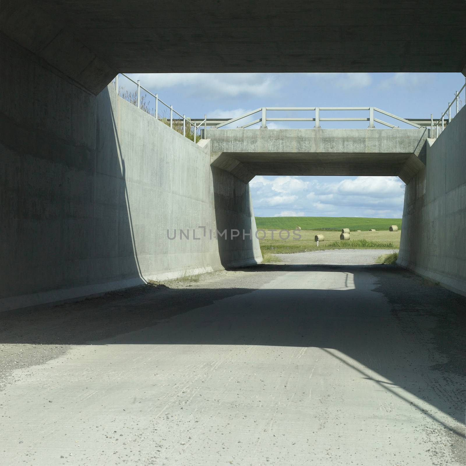 Overpass section of highway leading to a hay field