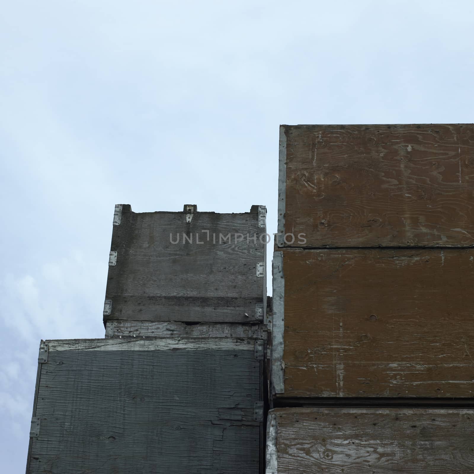 Stacks of large industrial crates against cloudy sky