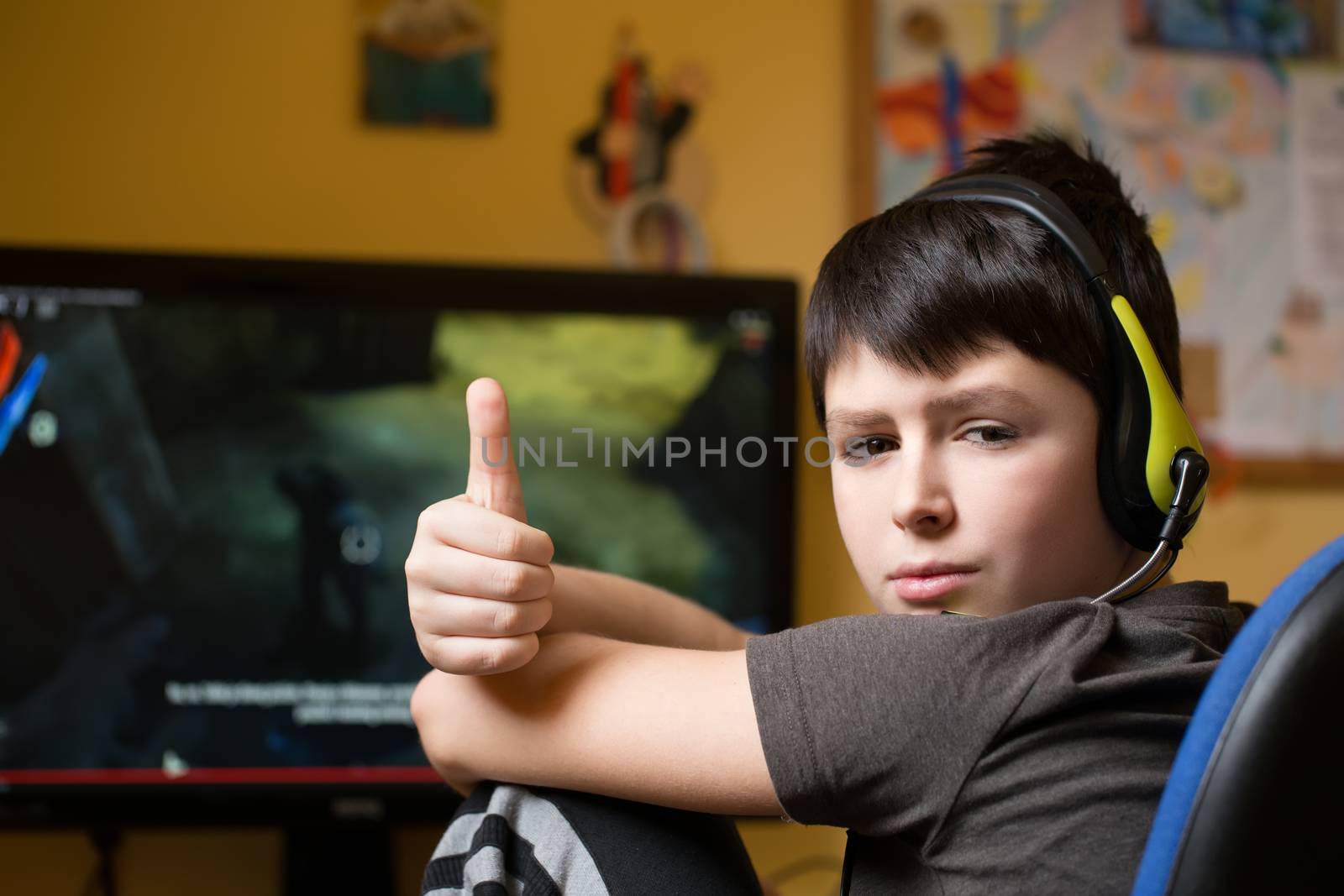 Boy using computer at home, playing game by artush