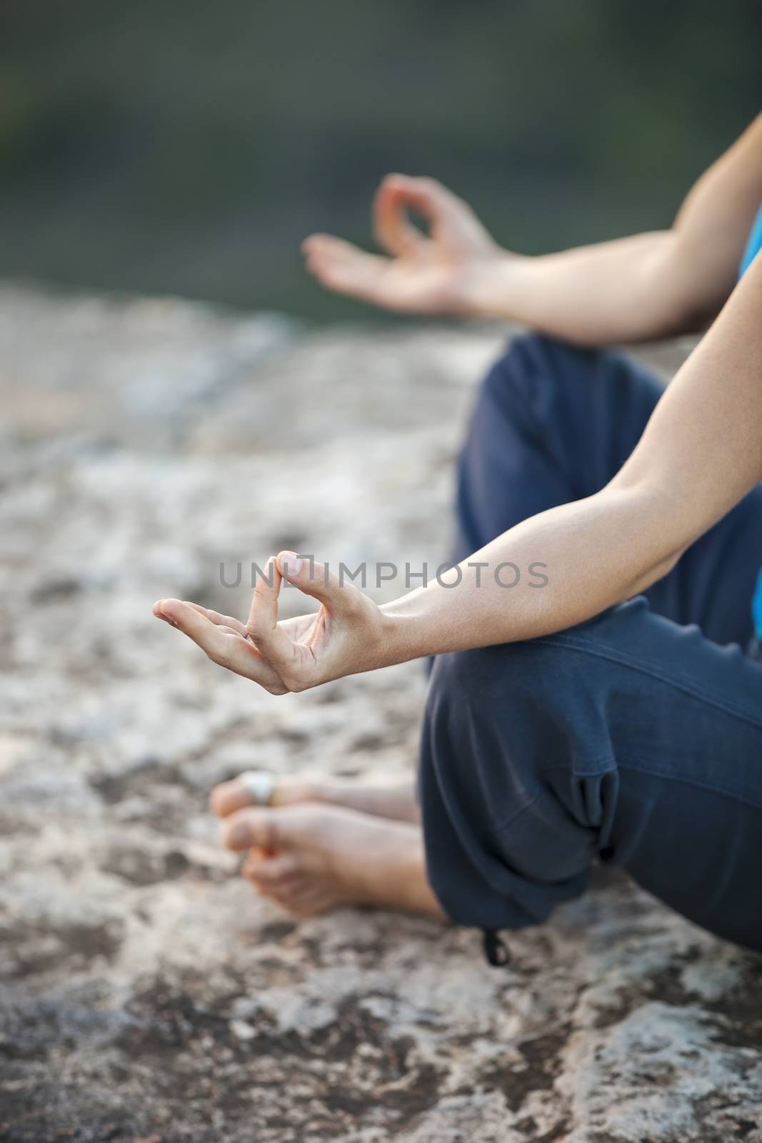 Close up of female hand zen gesturing. Girl sits in asana position