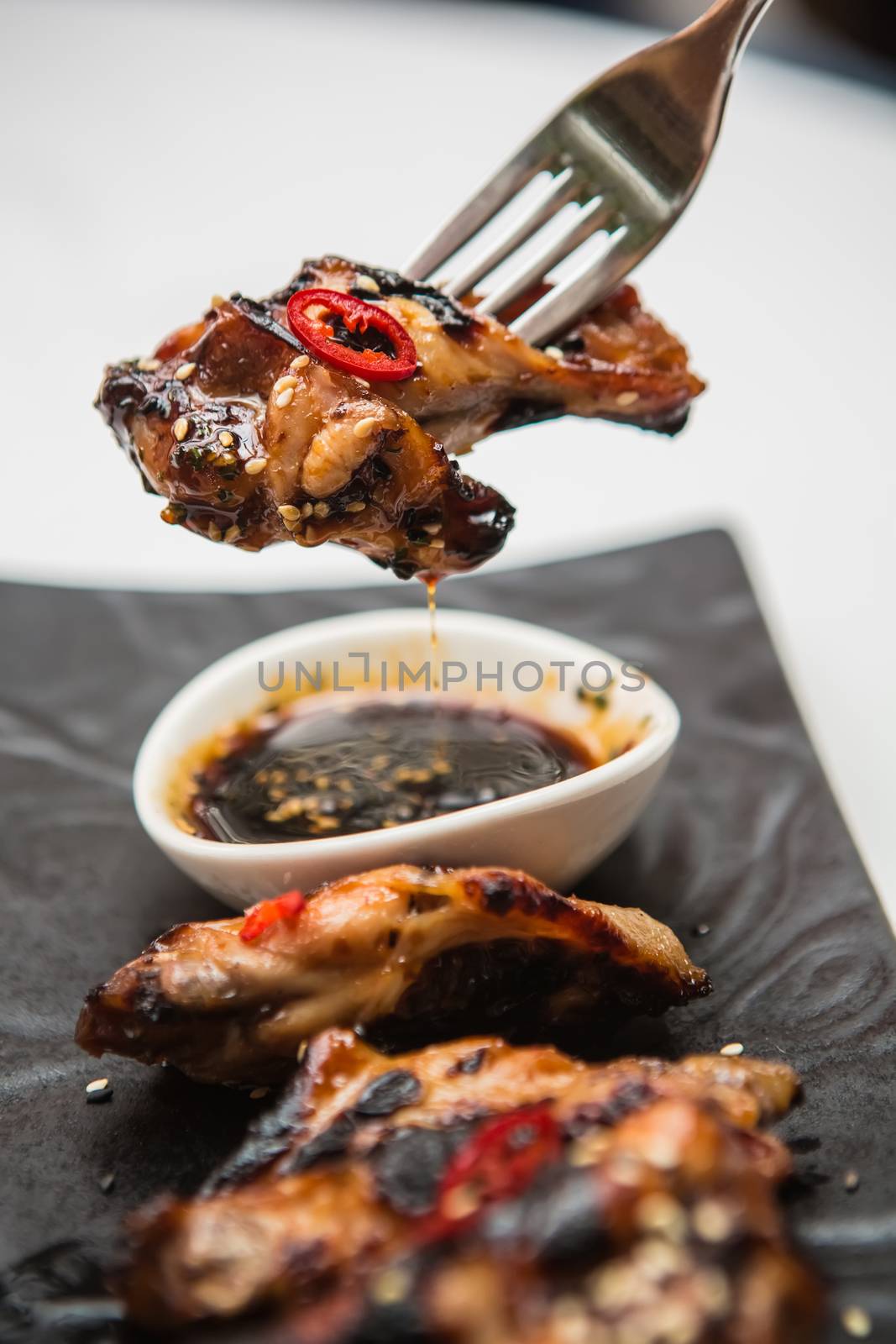 Hot organic chicken wings with red pepper on black dish