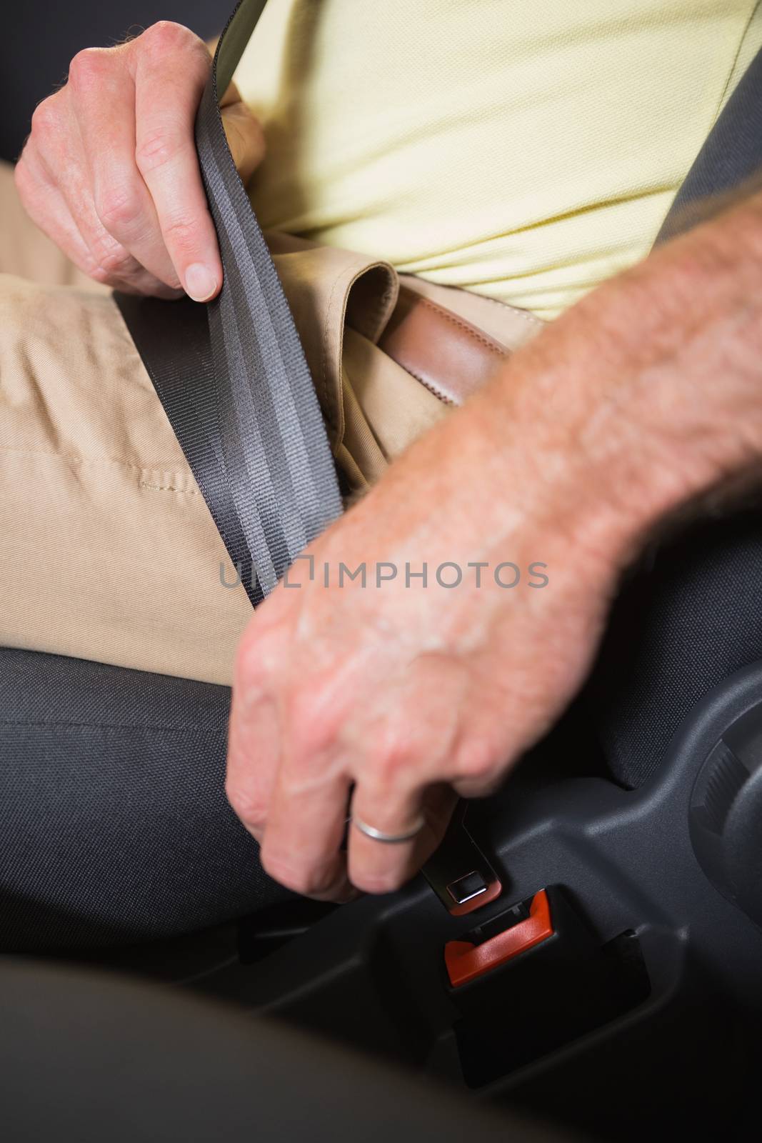 Close up of man putting seat belt by Wavebreakmedia