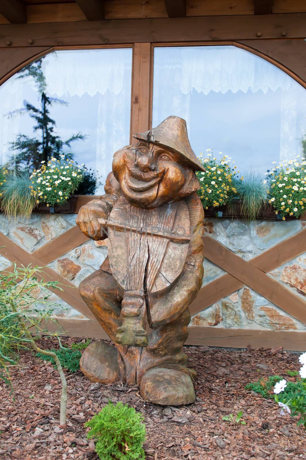 Ancient wooden sculpture depicts a man playing the violin buyout.