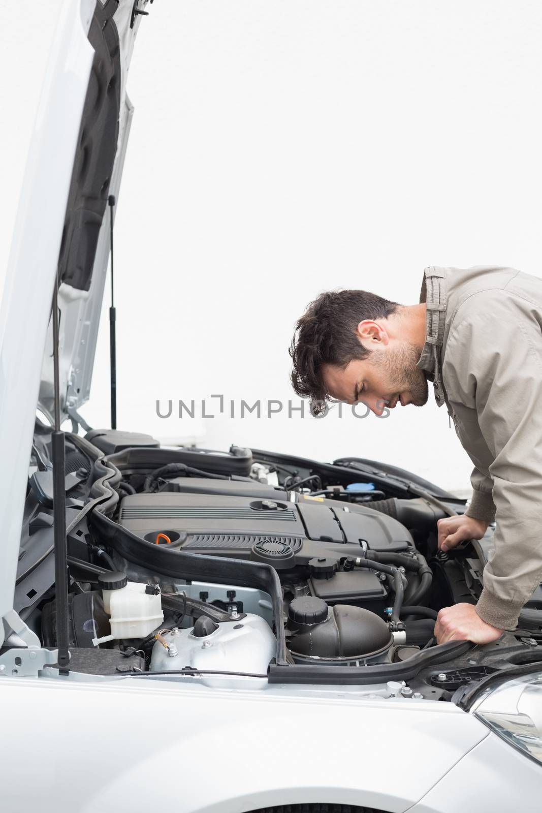 Stressed man looking at engine of his car