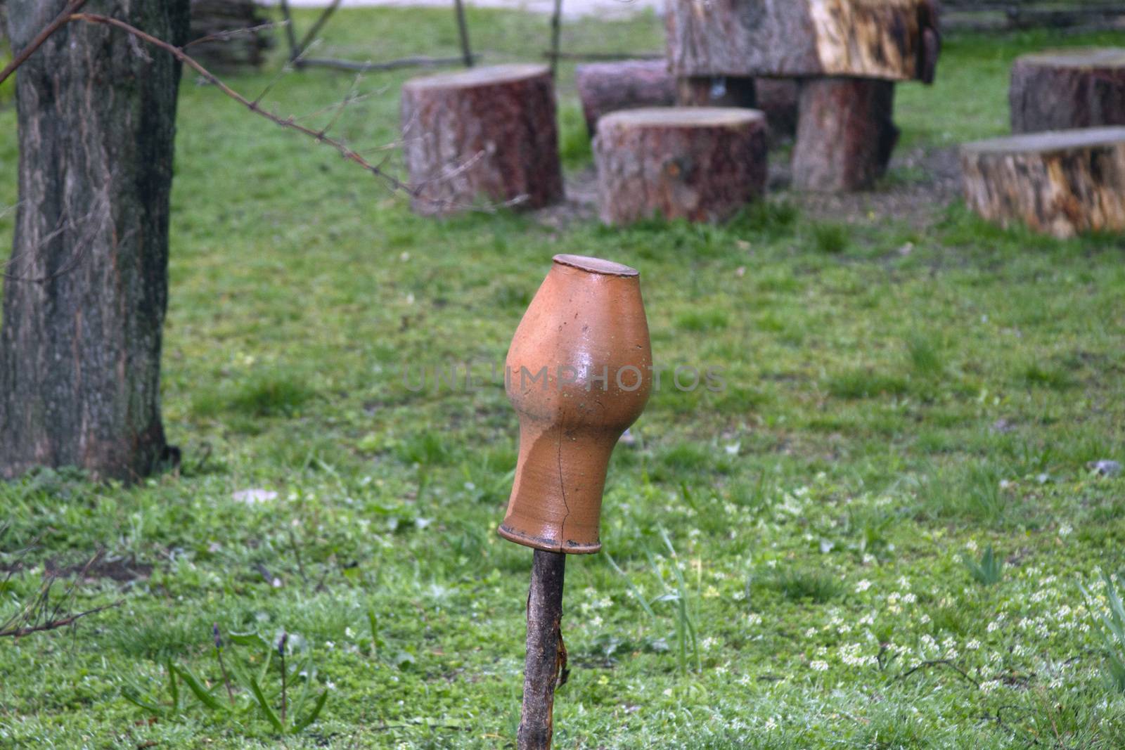 Milk pot hangs on an old fence of a village yard.